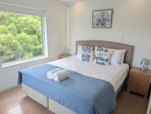 Ocean Breeze Apartment main bedroom with views to the bush from two large windows